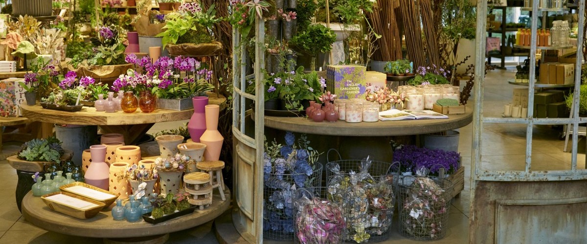 A lush shop interior packed with colorful flowers and decor.