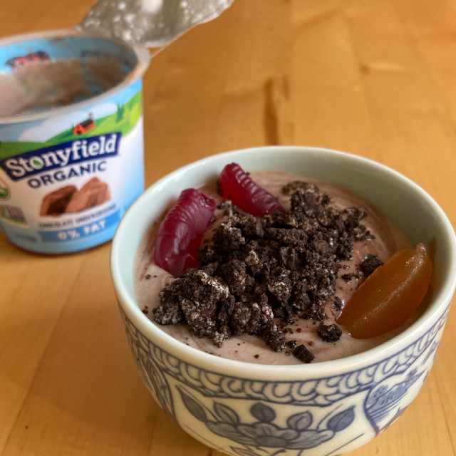 Chocolate yogurt in a bowl with gummy worms.