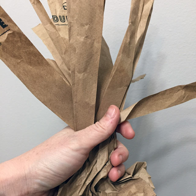 paper bag with strips being twisted to form tree